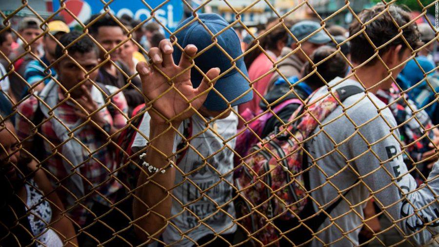 Honduran migrants wait outside the border between Guatemala and Mexico, in Tecun Uman, Guatemala, Friday, Oct. 19, 2018. Thousands of migrants traveling in a caravan briefly moved toward a border crossing on the Mexico-Guatemala frontier before turning around. Guatemala has closed its border gate and is standing guard with dozens of troops and two armored jeeps. (AP Photo/Oliver de Ros)